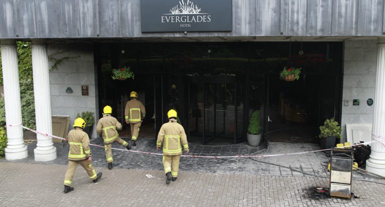 Members of the Fire Service are seen at the scene of a fire bomb at the Everglades Hotel, Londonderry, Northern Ireland, Friday, May, 30, 2014.  A masked man has thrown what police have described as a