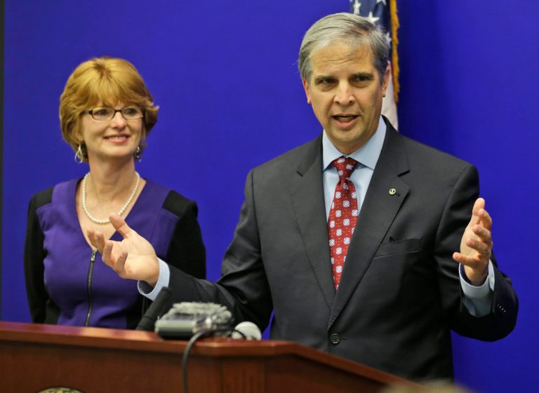 Virginia State Sen. Mark Obenshain gestures as his wife Suzanne looks on during a news conference at the Capitol in Richmond, Va., on Dec. 18. Obenshain conceded the race for Attorney General to Democrat Mark Herring after a recount showed his losing ground in votes. (AP Photo/Steve Helber)