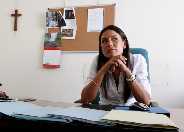 FILE - In this July 28, 2011 file photo, then Lombardy region councillor Nicole Minetti sits in her office, in Milan, Italy. Karima el-Mahroug, a Moroccan woman at the center of a sex scandal involving former Italian Premier Silvio Berlusconi, testified in Milan's courthouse, Italy, for the first time Friday, May 17, 2013 in the trial of three Berlusconi aides charged with recruiting her and other women for prostitution. El-Mahroug said one of the defendants, Nicole Minetti, had dressed up like a nun at a party at Berlusconi's villa outside Milan, and lifted her costume to show off her legs as she danced in the disco, which was outfitted with a lap-dance pole. El-Mahroug demonstrated from her seat how Minetti had raised her hemline. She said Minetti eventually took off her costume and was in just her lingerie. The trial is separate from one in which Berlusconi himself is charged with paying for sex with a minor and trying to cover it up. The three aides -- Emilio Fede, an executive in Berlusconi's media empire; Minetti, a former dental hygienist, showgirl and local politician, and talent agent Dario 