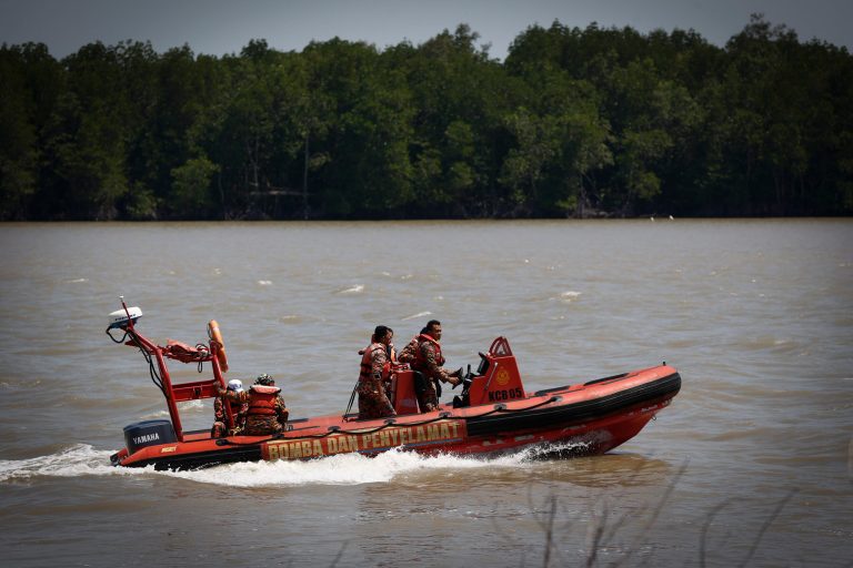 Malaysian Search and rescue personnel on a speed boat search for passengers of a sunken boat in outskirt of Banting, Malaysia, Wednesday, June 18, 2014. A wooden boat carrying more than 90 Indonesian migrants capsized and sank after leaving Malaysia's west coast, and rescuers scrambled to save more than 60 people still missing, Malaysia's maritime agency said Wednesday. (AP Photo/Vincent Thian)