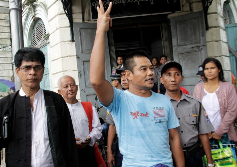 In this photo taken on Aug. 4, 2014, activist Htin Kyaw, right, shouts as he leaves a district court along with his lawyer Robert San Aung, left, after his trial in Yangon, Myanmar. A Myanmar court has sentenced the prominent human rights activist to two years in prison for marching through its biggest city and handing out leaflets that questioned the legitimacy of the country's new, nominally civilian government.  (AP Photo/Khin Maung Win)