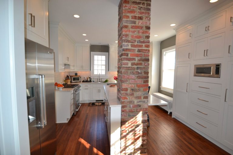 Kitchen designer Erin Hoopes used modern linear pulls on these traditionally styled inset white kitchen cabinets for a Del Ray home. Photo Credit: Greg Hadley