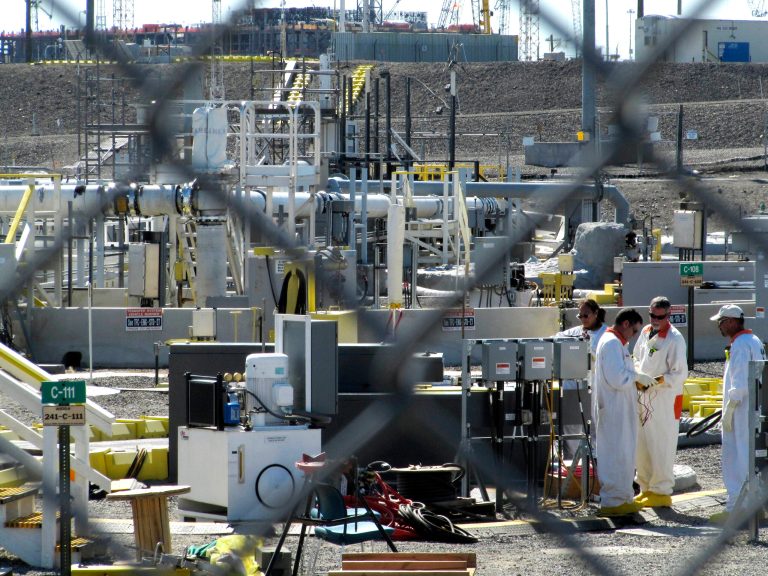 FILE - In this July 14, 2010 file photo, workers at the Hanford Nuclear Reservation stand near a tank farm where highly radioactive waste is stored underground near Richland, Wash. Few of the U.S. Department of Energy workers who are helping build the plant feel they can openly challenge decisions made by management, according to a report obtained Tuesday, June 24, 2014, by The Associated Press. (AP Photo/Shannon Dininny, File)