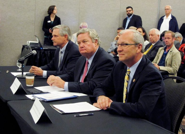 North Dakota Gov.  Gov. Jack Dalrymple, center, U.S. Sen. John Hoeven, R-N.D., left, and U.S. Rep. Kevin Cramer. R-N.D., listen to opening statements by the National Surface Transportation Board during a hearing on Thursday, Sept. 4, 2014, in Fargo, N.D. The hearing discussed delays in railroad grain shipments. (AP Photo/Dave Kolpack)