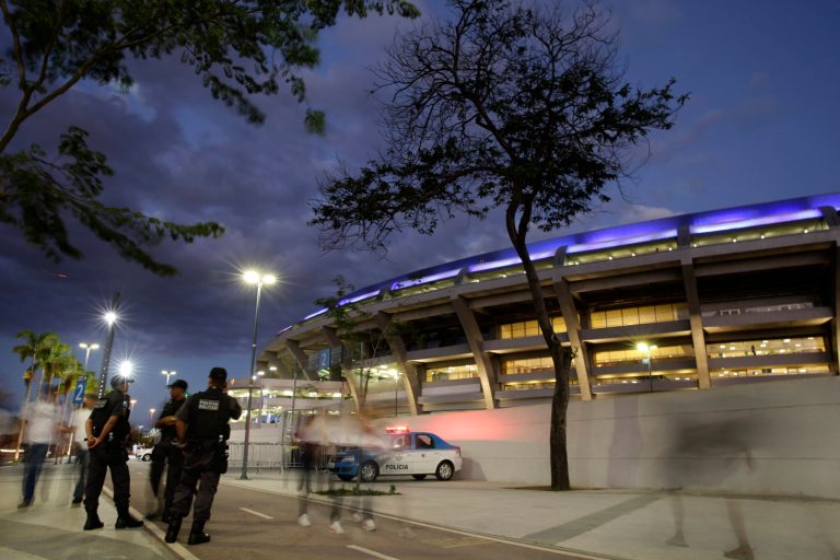 In this Sunday, May 11, 2014 photo, police stand outside the Maracana stadium, before a Brazilian league soccer match between Fluminense and Flamengo, in Rio de Janeiro, Brazil. Muggings on public transportation, public beaches and in popular tourist areas are on the rise in Rio de Janeiro, eroding the strides the city had made in security in recent years as it geared up to host six World Cup matches and the 2016 Olympic. (AP Photo/Hassan Ammar)