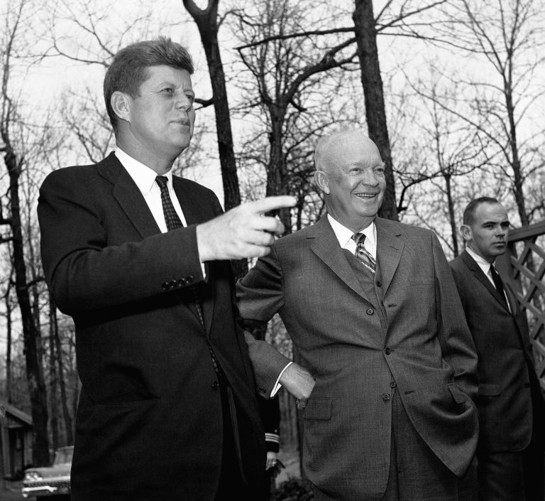 President John Kennedy points as former President Dwight Eisenhower looks out over Camp David after the two conferred on April 22, 1961 at the presidential hideaway at Thurmont, Maryland on the Cuban situation. (AP Photo)