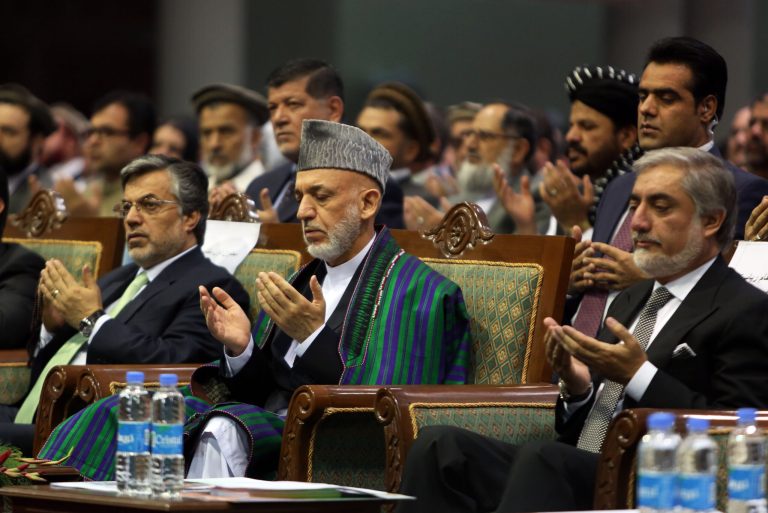 Afghan President Hamid Karzai, center, and Afghan presidential candidate Abdullah Abdullah pray during a ceremony marking the third anniversary of the assassination of former Afghan President Burhanuddin Rabbani in Kabul, Afghanistan, Saturday, Sept. 20, 2014. In 2011, an insurgent with a bomb wrapped in his turban assassinated Rabbani, who was leading a government effort to broker peace with the Taliban. (AP Photo/Rahmat Gul)