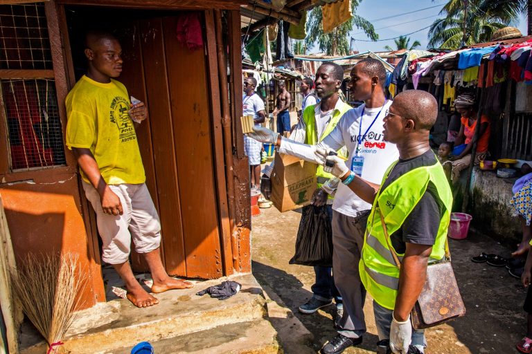Health worker volunteers talk to a resident to distribute bars of soap and information about Ebola in Freetown, Sierra Leone, Saturday, Sept. 20, 2014. Thousands of health workers began knocking on doors across Sierra Leone on Friday in search of hidden Ebola cases with the entire West African nation locked down in their homes for three days in an unprecedented effort to combat the deadly disease. (AP Photo/Michael Duff)