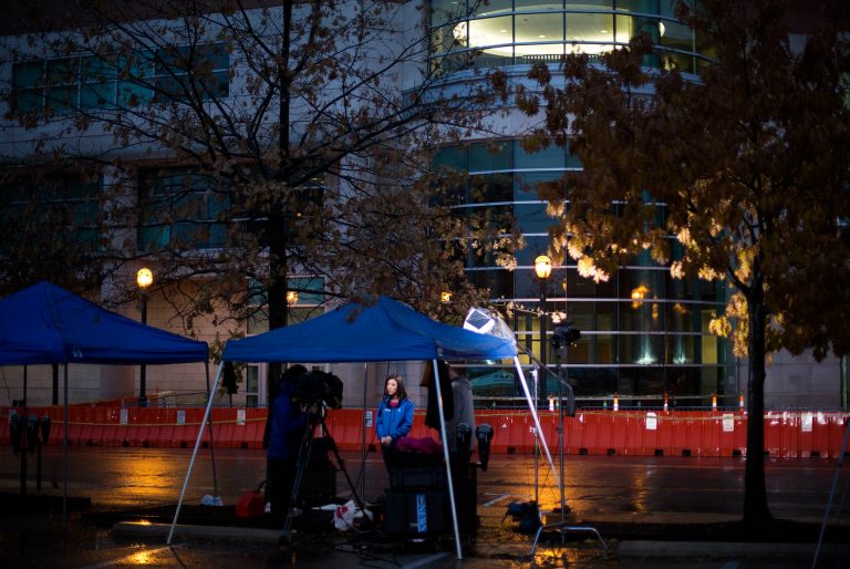 A television news reporter conducts a broadcast outside the Buzz Westfall Justice Center where a grand jury was to convene to consider charges against the police officer who fatally shot Michael Brown in nearby Ferguson, Sunday, Nov. 23, 2014, in Clayton, Mo. (AP Photo/David Goldman)