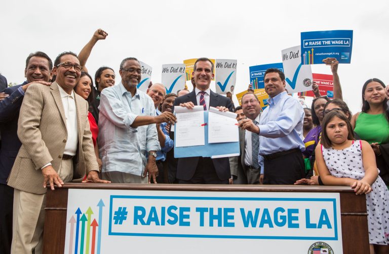 Los Angeles Mayor Eric Garcetti, center, joins members of the City Council and community leaders in a photo after he signed into law an ordinance that will gradually raise the minimum wage to $15 an hour by 2020, in at Martin Luther King Jr. Park in Los Angeles, Saturday, June 13, 2015. The ordinance makes Los Angeles the largest city in the U.S. to gradually raise the minimum wage to $15 an hour. (AP Photo/Ringo H.W. Chiu)