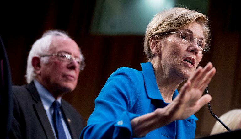 Sen. Elizabeth Warren, D-Mass., right, accompanied by Sen. Bernie Sanders, I-Vt., left, speaks during a news conference on Capitol Hill in Washington on Wednesday, Sept. 13, 2017. (AP Photo/Andrew Harnik)