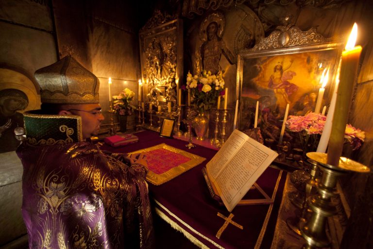 File - In this Friday, May 18, 2012 file photo, an Armenian Orthodox priest holds liturgy at the tomb of Jesus in the Church of the Holy Sepulcher in Jerusalem. Pope Francis and the spiritual leader of the world's Orthodox Christians could not have chosen a more fitting meeting place to promote Christian unity on Sunday than the Jerusalem holy site where their churches' centuries-old rivalries and machinations play out every day. The Church of the Holy Sepulcher, where the pope will meet Ecumenical Patriarch Bartholomew I in the central event of his Holy Land trip, marks the spot where Roman Catholic and Orthodox Christians believe Jesus was crucified, buried and resurrected. (AP Photo/Dusan Vranic, File)