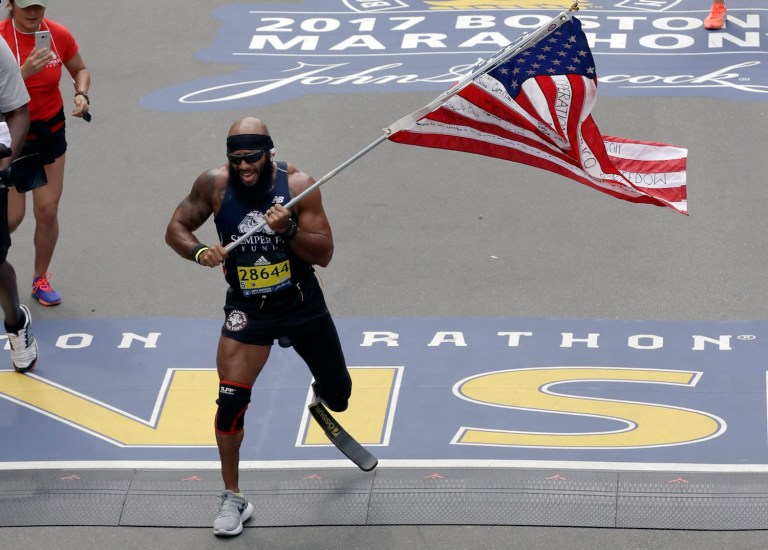 Retired Texas Marine Staff Sgt. Jose Sanchez was injured in Afghanistan in 2011. He carried his fellow Marines' words with him as he crossed the finish line. (AP Photo/Charles Krupa)