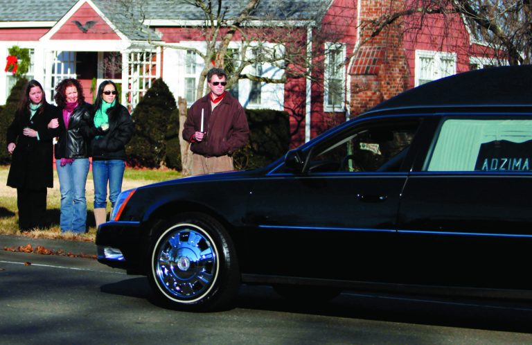 A hearse bearing the body of Victoria Soto drives past a group of onlookers as it arrives for her funeral service at Lordship Community Church, Wednesday, Dec. 19, 2012, in Stratford, Conn. Soto was killed when a gunman forced his way into Sandy Hook Elementary School in Newtown, Dec.14, and opened fire, killing 26 people, including 20 children. (AP Photo/Jason DeCrow)