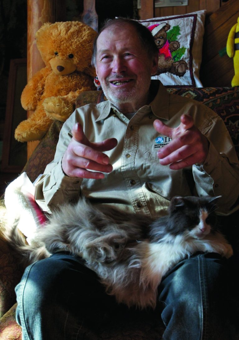 ADVANCE FOR USE SUNDAY, AUG. 5, 2012 AND THEREAFTER - In this Friday, April 6, 2012 photo, Valentin Pazhetnov, honored Russian biologist and creator for the protocol at the International Fund for Animal Welfare's Bear Rescue and Rehabilitation Program, speaks to reporters with a cat in his lap in his home near the village of Bubonitsy, Russia, 350 kilometers (220 miles) northwest of Moscow. Pazhetnov, who founded the program, says minimal contact with humans is necessary so that the cubs learn to fend for themselves. (AP Photo/Alexander Zemlianichenko)