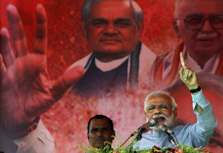 India's main opposition Bharatiya Janata Party's prime ministerial candidate Narendra Modi addresses his supporters during a campaign rally at Balasore, 200 kilometers (124 miles) from the eastern Indian city of Bhubaneswar, India, Friday, April 11, 2014. Indians voted in the crucial third phase of national elections Thursday, with millions going to the polls in the heartland states that are essential to the main opposition Hindu nationalist party's bid to end the 10-year rule of Congress party. Portraits in the background show former prime minister Atal Bihari Vajpayee, left, and senior party leader L.K. Advani. (AP Photo/Biswaranjan Rout)