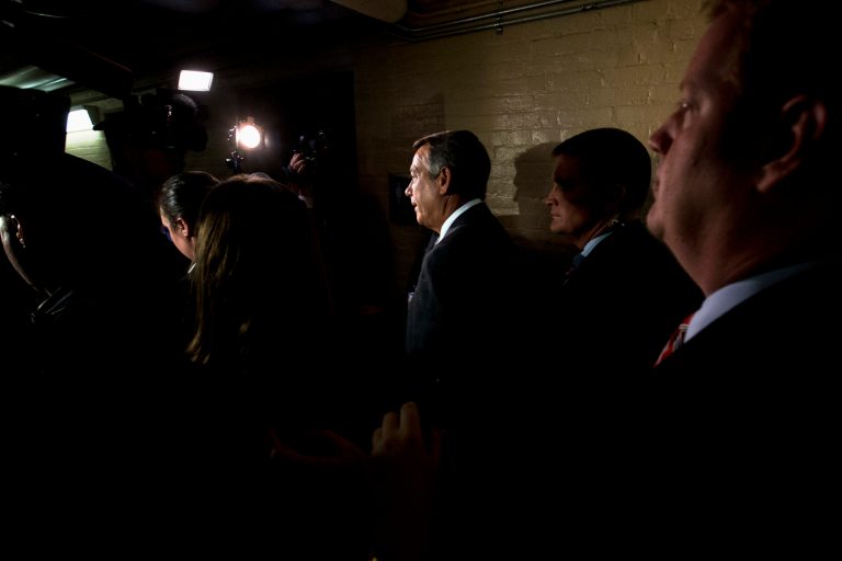 Highlighted by television camera lights, House Speaker John Boehner of Ohio, leaves a meeting with House Republicans announcing his resignation, Friday, Sept. 25, 2015 on Capitol Hill in Washington. (AP Photo/Jacquelyn Martin)
