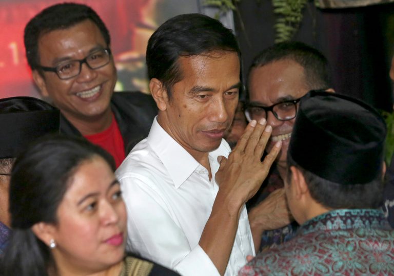 Presidential candidate Joko Widodo, center, gestures after a press conference in Jakarta, Indonesia, Tuesday, July 22, 2014. Jakarta governor Joko Widodo, who captured the hearts of millions of Indonesians with his common man image, won the country's presidential election with 53 percent of the vote, final results showed Tuesday. (AP Photo/Tatan Syuflana)