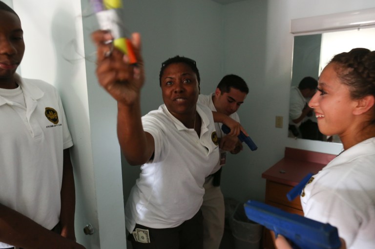 Crystal Reese, an FBI field office audit supervisor, holds a fake explosive during a training exercise with students from the Future Agents in Training program.