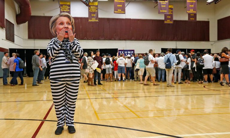 Supporter of Republican presidential candidate Donald Trump, Beth Lyerla of Gilbert, Ariz., wears a Hillary Clinton mask and a prison outfit as she waits for Donald Trump Jr. to speak at a campaign rally for his father at Arizona State University Thursday, Oct. 27, 2016, in Tempe, Ariz. (AP Photo/Ross D. Franklin)