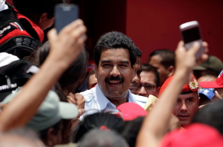 Venezuela's interim President Nicolas Maduro smiles as he's surrounded by supporters during a campaign rally in Sabaneta, Barinas state, Venezuela, Tuesday, April 2, 2013. Late President Hugo Chavez's chosen successor, Nicolas Maduro is competing against opposition leader Henrique Capriles in the April 14 presidential election. (AP Photo/Ariana Cubillos)