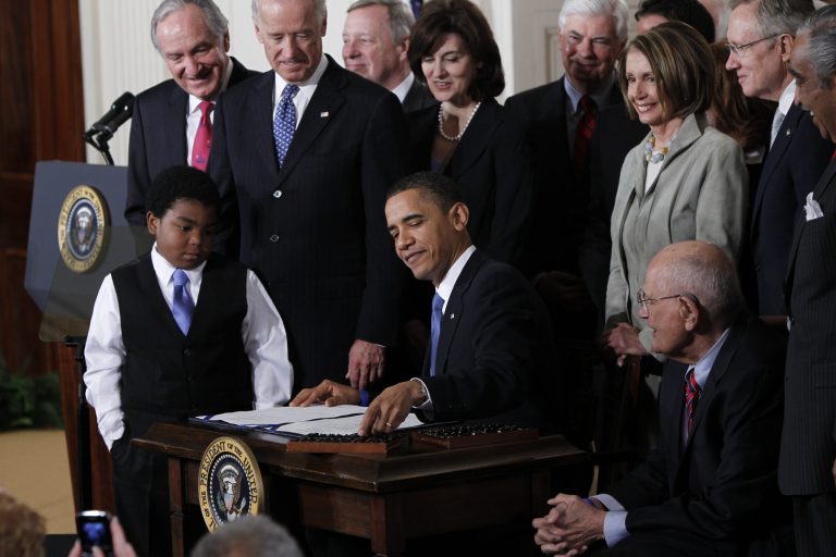 FILE - In this March 23, 2010, file photo, President Barack Obama reaches for a pen to sign the health care bill in the East Room of the White House in Washington. Several million American workers will cut back their hours on the job or leave the nation's workforce entirely because of Obama's health care overhaul, congressional analysts said Tuesday, Feb. 4, 2014, adding fresh fuel to the political fight over 