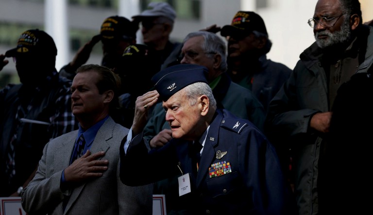 U.S. Air Force retired Col. James L. Wolfe, front, salutes stands with other veterans during the national anthem before a Veterans Day parade in Dallas, Friday, Nov. 10, 2017. (AP Photo/LM Otero)