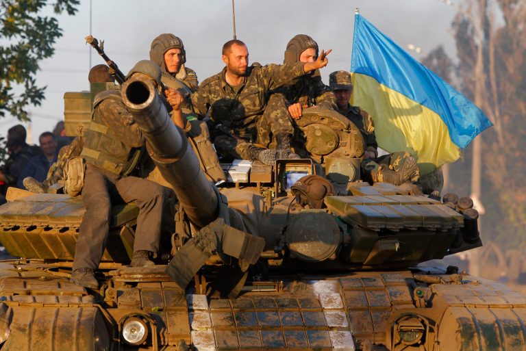 Soldiers of Ukrainian army ride on a tank in the port city of Mariupol, southeastern Ukraine, Friday, Sept. 5, 2014. The Ukrainian president declared a cease-fire Friday to end nearly five months of fighting in the nation's east after his representatives reached a deal with the Russian-backed rebels at peace talks in Minsk. (AP Photo/Sergei Grits)