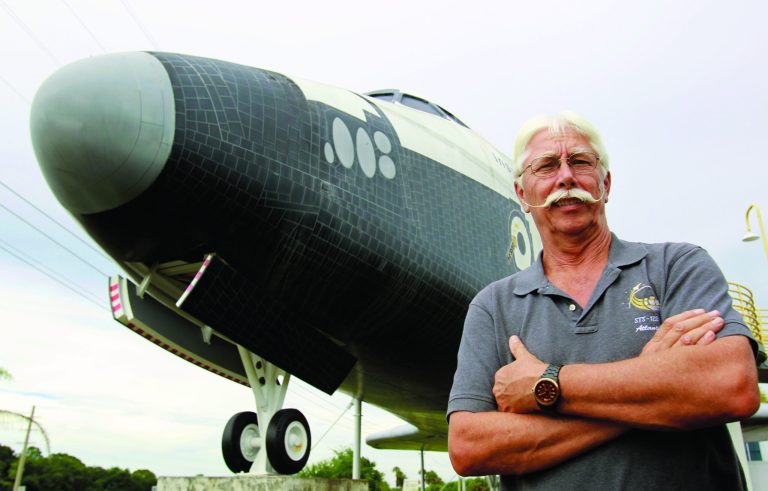In this Wednesday, July 11, 2012 photo, former space shuttle worker Terry White poses in front of a mock space shuttle at the Astronaut Hall of Fame in Titusville, Fla. White was a project manager who worked 33 years for the shuttle program until he was laid off after Atlantis landed last July 21. (AP Photo/John Raoux)