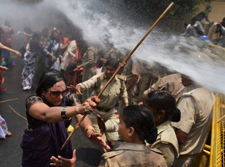 An Indian woman, left, one among the protestors demonstrating outside the office of Uttar Pradesh state chief minister Akhilesh Yadav, demanding that he crack down on an increasing number of rape and other attacks on women and girls, scuffles with police in Lucknow, India, Monday, June 2, 2014. Police used water cannons to disperse hundreds of women who were protesting Monday against a rise in violence against women in the northern Indian state where two teenagers were gang-raped last week and later found hanging from a tree. (AP Photo)