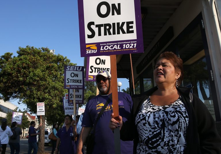 Bay Area Rapid Transit (BART) union workers with SEIU Local 1021 hold signs as they picket in front of the Lake Merritt station on July 2, 2013 in Oakland, California.