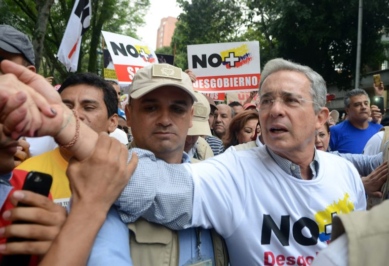 Former President Alvaro Uribe shakes hands with a supporter as he takes part in a protest against President Juan Manuel Santos' government and to denounce the concessions the government has made in peace talks with the Revolutionary Armed Forces of Colombia, or FARC, in Medellin, Colombia. (AP Photo/Luis Benavides, File)
