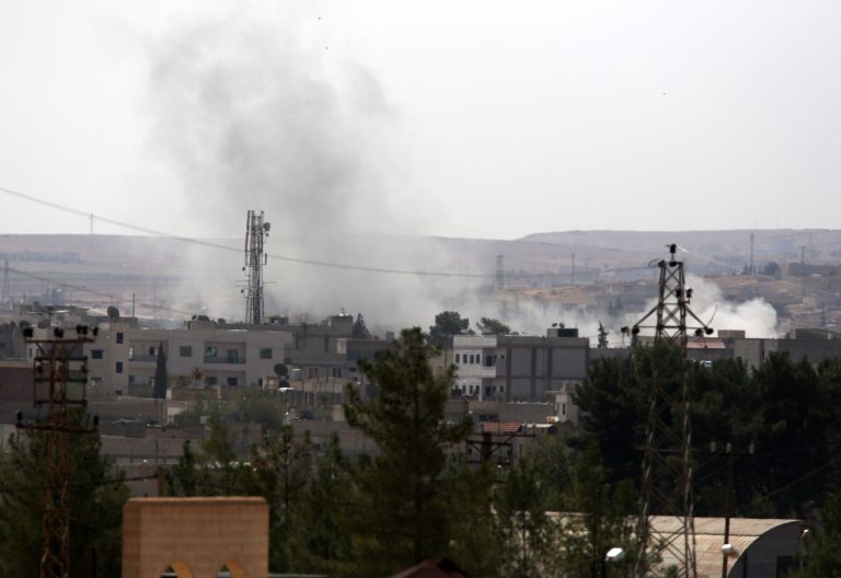 Smoke rises after a mortar shell landed in the west part of the city center of Kobani in Syria as fighting intensified between Syrian Kurds and the militants of Islamic State group, seen from Mursitpinar near Suruc, Turkey, Friday, Oct. 3, 2014.  Turkey's parliament approved Thursday a motion that gives the government new powers to launch military incursions into Syria and Iraq and to allow foreign forces to use its territory for possible operations against the Islamic State group. (AP Photo/Burhan Ozbilici)