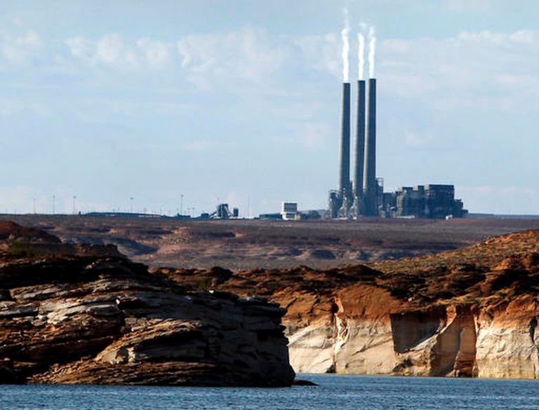Amoke rises from the stacks of the main plant facility at the Navajo Generating Station, as seen from Lake Powell in Page, Ariz. The coal-fired power plant in far northern Arizona that was built to deliver water to the state's desert region is set to retire in 2019 unless a new owner can be found. (AP File Photo/Ross D. Franklin)