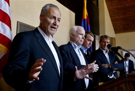 Sen. Chuck Schumer, D-N.Y., left, speaks to the media as, from second left, Sen. John McCain, R-Ariz., Sen. Michael Bennett, D-Colo., and Sen. Jeff Flake, R-Ariz., listen in during a news conference after their tour of the Mexico border with the United States on Wednesday, March 27, 2013, in Nogales, Ariz.   The senators are part of a larger group of legislators shaping and negotiating details of an immigration reform package vowed Wednesday to make the legislation public when Congress reconvenes next month. (AP Photo/Ross D. Franklin)