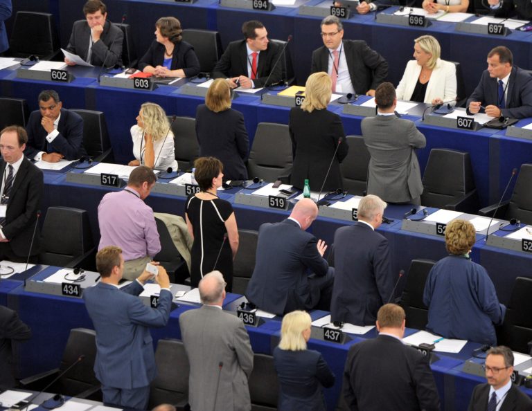 Eurosceptic members of the European Parliament, turn their back as an orchestra performs the European anthem in the European parliament in Strasbourg, eastern France, Tuesday, July 1, 2014, on the inaugural day of the session, after general elections in the 27 countries of the European Union. (AP Photo/Christian Lutz)