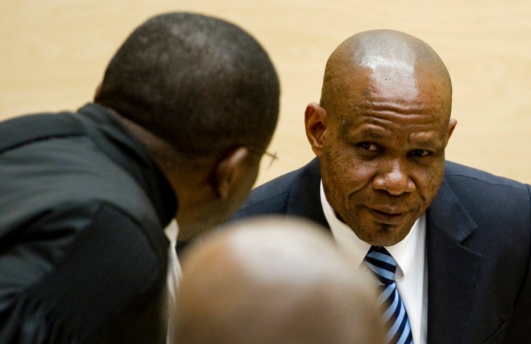   Former leader of the National Integrationist Front, Mathieu Ngudjolo, right, listens to his lawyer prior to his verdict at the International Criminal Court (ICC) in The Hague, Netherlands, Tuesday, Dec. 18, 2012. The ICC acquitted Ngudjolo of all charges of leading fighters who destroyed a strategic village in eastern Congo, hacking to death and raping some 200 people including women and children in 2003. Tuesdayâs acquittal is only the second verdict in the courtâs 10-year history and the first time it has cleared a suspect. (AP Photo/Robin van Lonkhuijsen, Pool)  