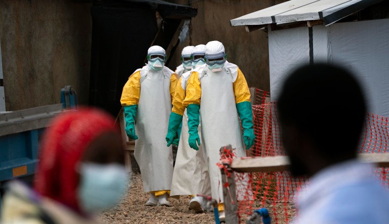 In this Tuesday, July 16, 2019 photo, health workers dressed in protective gear begin their shift at an Ebola treatment center in Beni, Congo DRC.