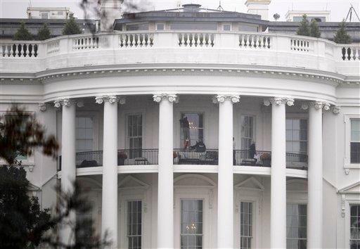 Law enforcement officers photograph a window at the White House in Washington, Wednesday, Nov. 16, 2011, as seen from the South Lawn. A bullet hit an exterior window of the White House and was stopped by ballistic glass, the Secret Service said. An additional round of ammunition was found on the White House exterior. The bullets were found Tuesday morning.