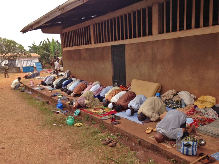 In this photo taken on Sunday, Feb. 23, 2014, Muslims pray as they hide at a Catholic church in Carnot a town 200 kilometers (125 miles) from the Cameroonian border, in, Central African Republic. The Christian militiamen knew hundreds of Muslims were hiding at the Catholic church and came with their ultimatum: Evict the families to face certain death or else the entire place would be burned to the ground.  (AP Photo/Krista Larson)