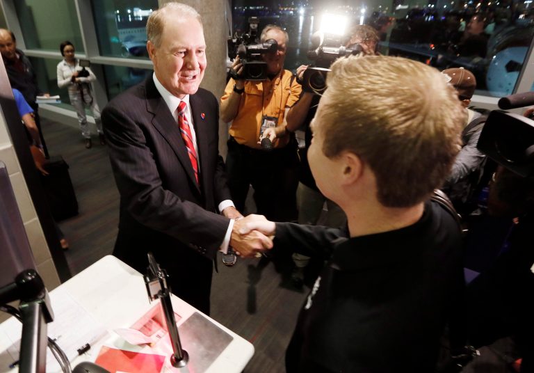Southwest Airlines CEO Gary Kelly checks in the first passenger for flight 1013 to Denver, the first non-restricted flight out of Love Field, in Dallas, Monday, Oct. 13, 2014. Limits on flights at Dallas Love Field died Monday after more than three decades, and Southwest Airlines Co. and Virgin America launched new long-haul service. (AP Photo/The Fort Worth Star-Telegram, Brandon Wade)  MAGS OUT; (FORT WORTH WEEKLY, 360 WEST); INTERNET OUT