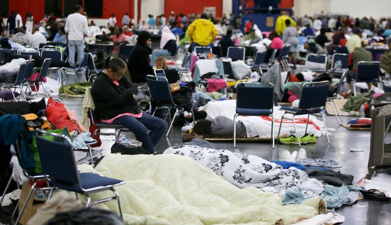 People rest at a convention center that has been set up as a shelter for evacuees escaping the floodwaters from Tropical Storm Harvey in Houston. (AP Photo/LM Otero)