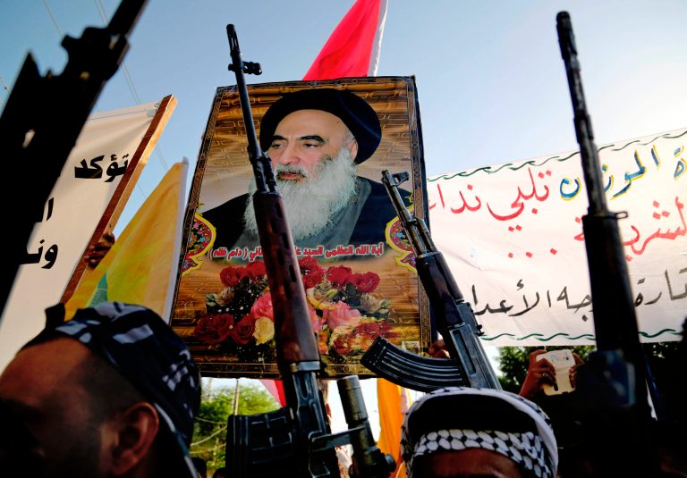 Shiite tribal fighters carry a poster of Shiite spiritual leader Grand Ayatollah Ali al-Sistani, as they raise their weapons chanting slogans against the al-Qaida-inspired Islamic State of Iraq and the Levant in Basra, Iraq's second-largest city. (AP/Nabil Al-Jurani)