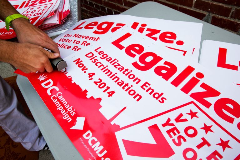 In this photo taken Oct. 9, 2014, Adam Eidinger, chairman of the DC Cannabis Campaign, works on posters encouraging people to vote yes on DC Ballot Initiative 71 to legalize small amounts of marijuana for personal use, in Washington. Legalized weed would look far different in the nation's capital than it does in other places that have chosen to decriminalize marijuana. Even if voters approve it next month, as appears likely, it would remain banned in the roughly one-fourth of the District of Columbia that is federal land, so there would still be no lighting a joint in front of the Jefferson Memorial. The capital also remains under the thumb of Congress, which could quash legalization in D.C. regardless of what the voters want. (AP Photo/Jacquelyn Martin)