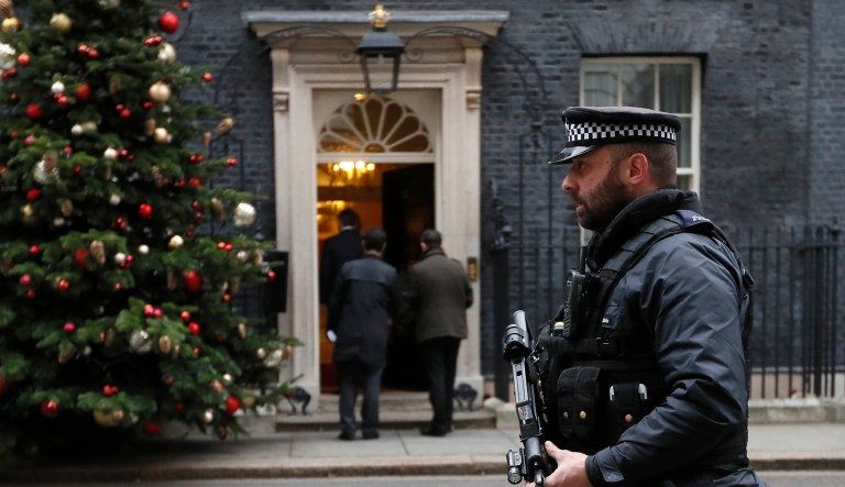 An armed police officer keeps guard at Downing Street in London, Wednesday, Dec. 6, 2017. Two men will appear in a London court to face terror charges Wednesday after reportedly plotting to assassinate British Prime Minister Theresa May. The plan, revealed to the British Cabinet on Tuesday, allegedly involved planting a bomb outside the entrance to Downing Street gates before attackers would stab the U.K. leader in the ensuing chaos. (AP Photo/Kirsty Wigglesworth)