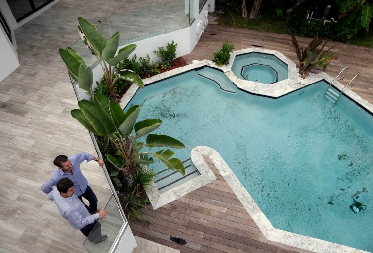In this Sept. 24, 2014 photo, developer Michael Capponi, left, talks with real estate broker Massimo Nicastro, right, of South Beach Estates, at a waterfront property he renovated, during a viewing for brokers, in Miami Beach, Fla. Standard & Poor's releases S&P/Case-Shiller index of home prices for July on Tuesday, Sept. 30, 2014. (AP Photo/Lynne Sladky)