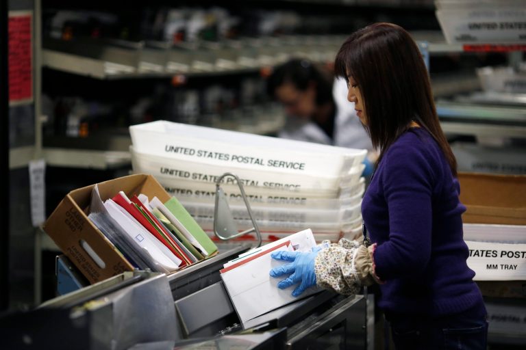 An United States Postal Office employee puts a bundle of mail onto a machine at the Processing and Distribution Center on December 16, 2013 in San Francisco, California. (Photo by Stephen Lam/Getty images)