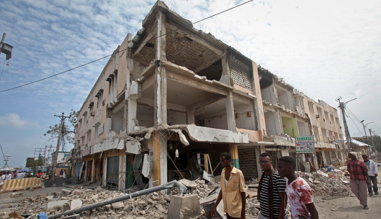 Men walk near destroyed buildings as thousands of Somalis gathered to pray at the site of the country's deadliest attack and to mourn the hundreds of victims, at the site of the attack in Mogadishu, Somalia Friday, Oct. 20, 2017. More than 300 people were killed and nearly 400 wounded in Saturday's truck bombing, with scores missing. (AP Photo/Farah Abdi Warsameh)