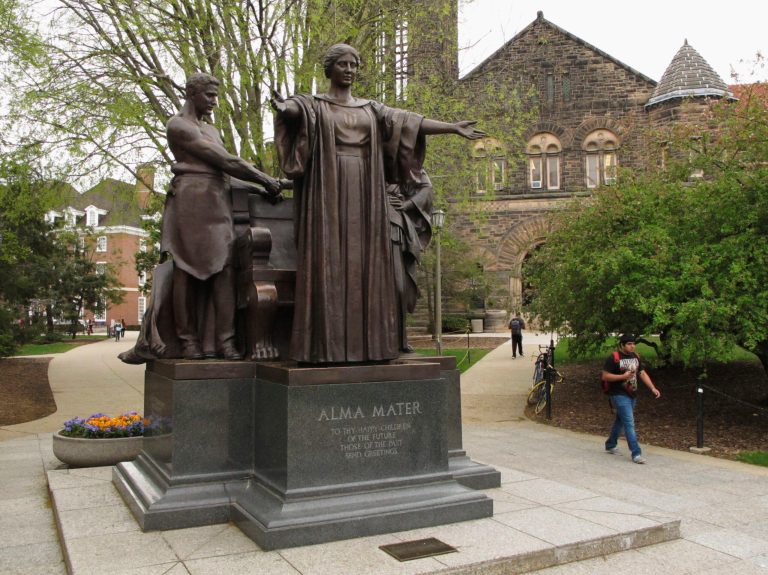Students walk past the Alma Mater statue, a landmark on the University of Illinois campus in Urbana, Ill. Public universities in Illinois are bracing for waves or retirements because a state pension-reform law will sharply cut their retirement funds. (AP Photo/David Mercer)