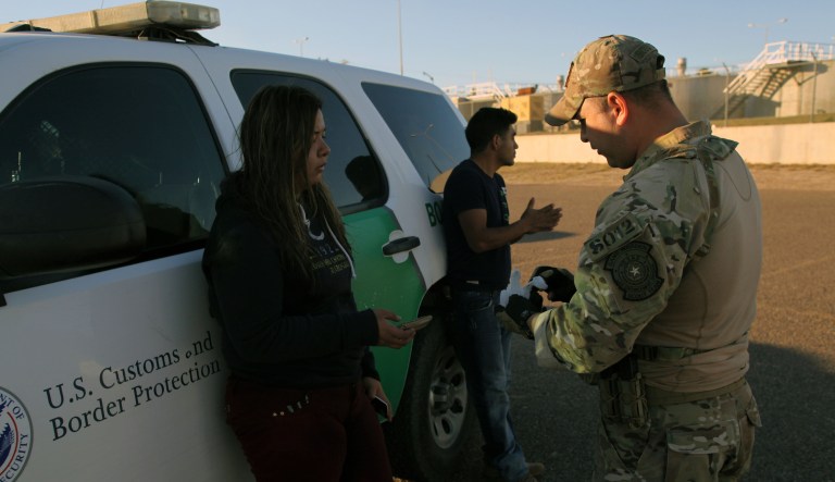 A Texas Game Warden working with the Border Patrol takes a Mexican woman into custody for illegally entering the U.S.